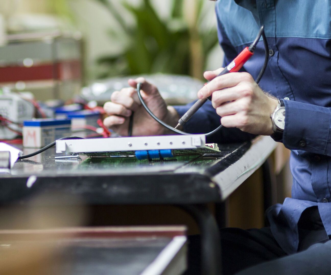 Eine Person lötet etwas an einem Tisch